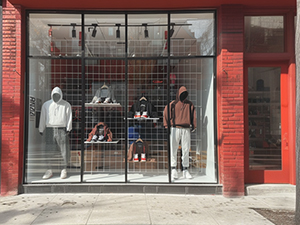An image of a window display of athletic clothes in a red brick building
