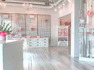 An image of a retail store selling pink merchandise with a black wire grid in the background